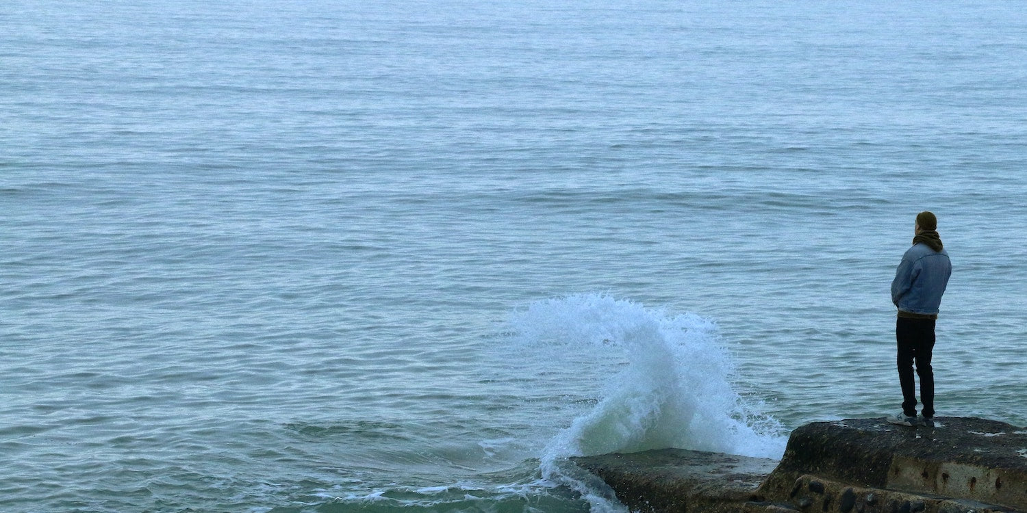 Man Looking Out At The Ocean
